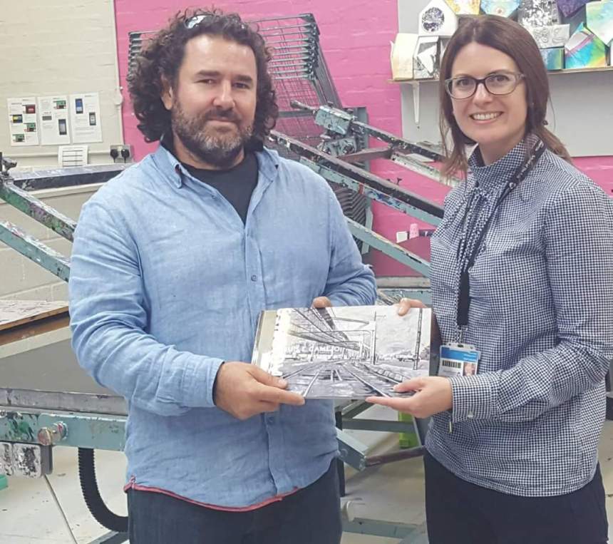 Artist Luis Camejo presents tutor Catriona Leahy with a book of his work at Northampton university